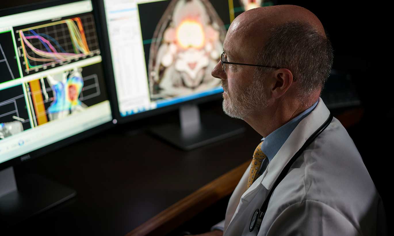 A doctor studies the results of patient tests and scans in his office in Forest Country, Texas