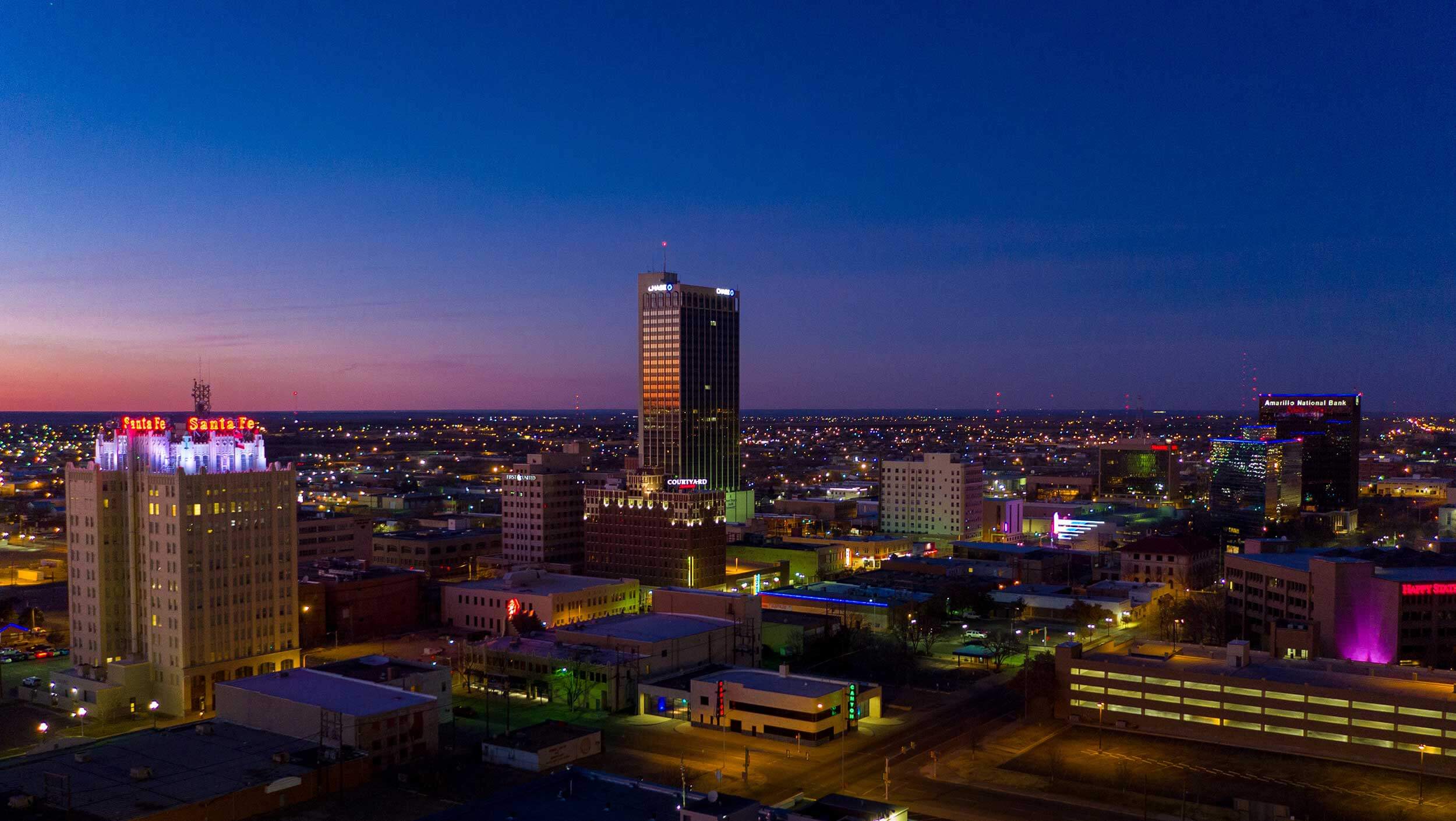 Aerial view of downtown Amarillo, Texas at night, lit up with brightly colored lights