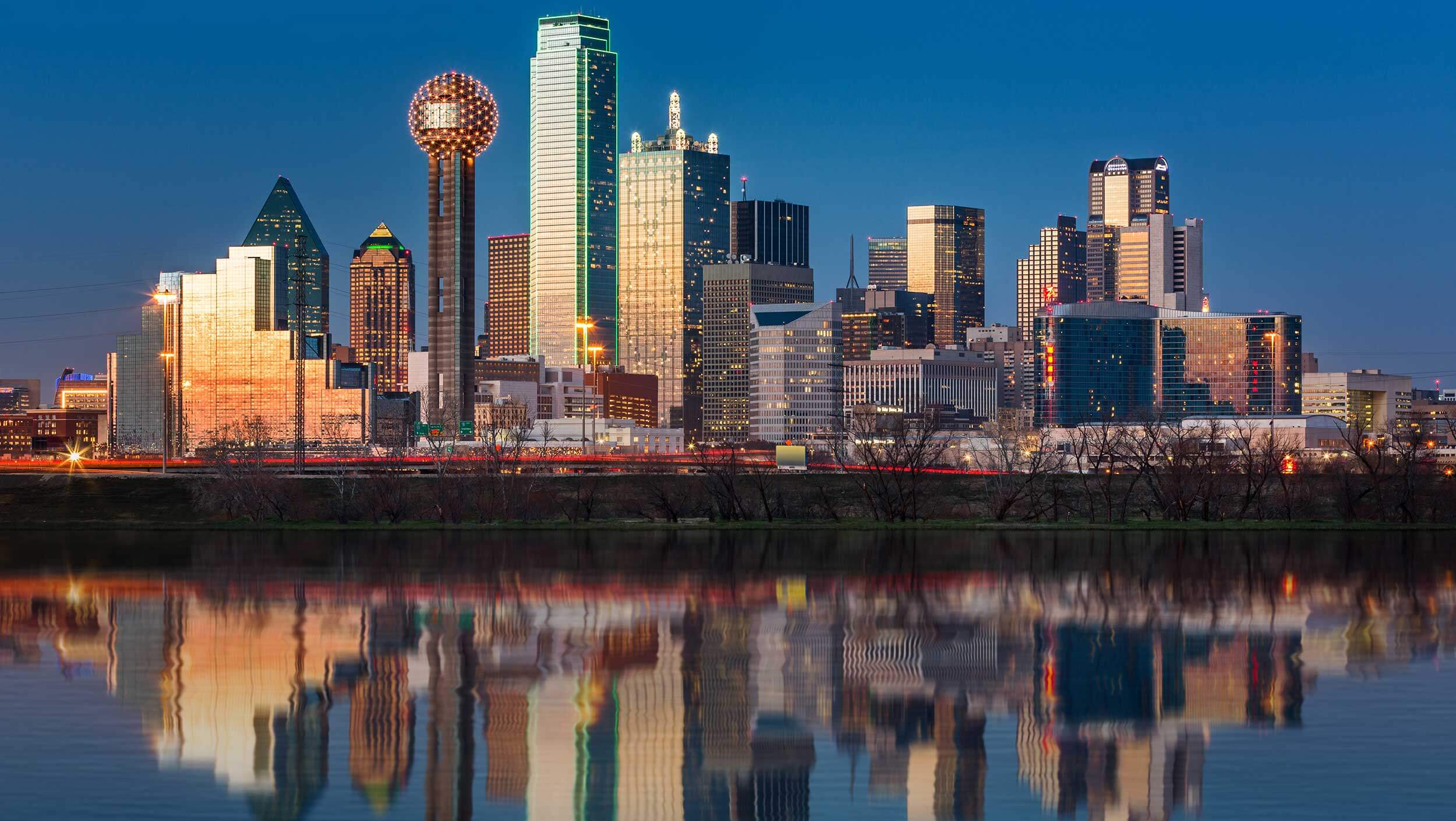 View of the Dallas skyline across the water with the buildings reflected in the water