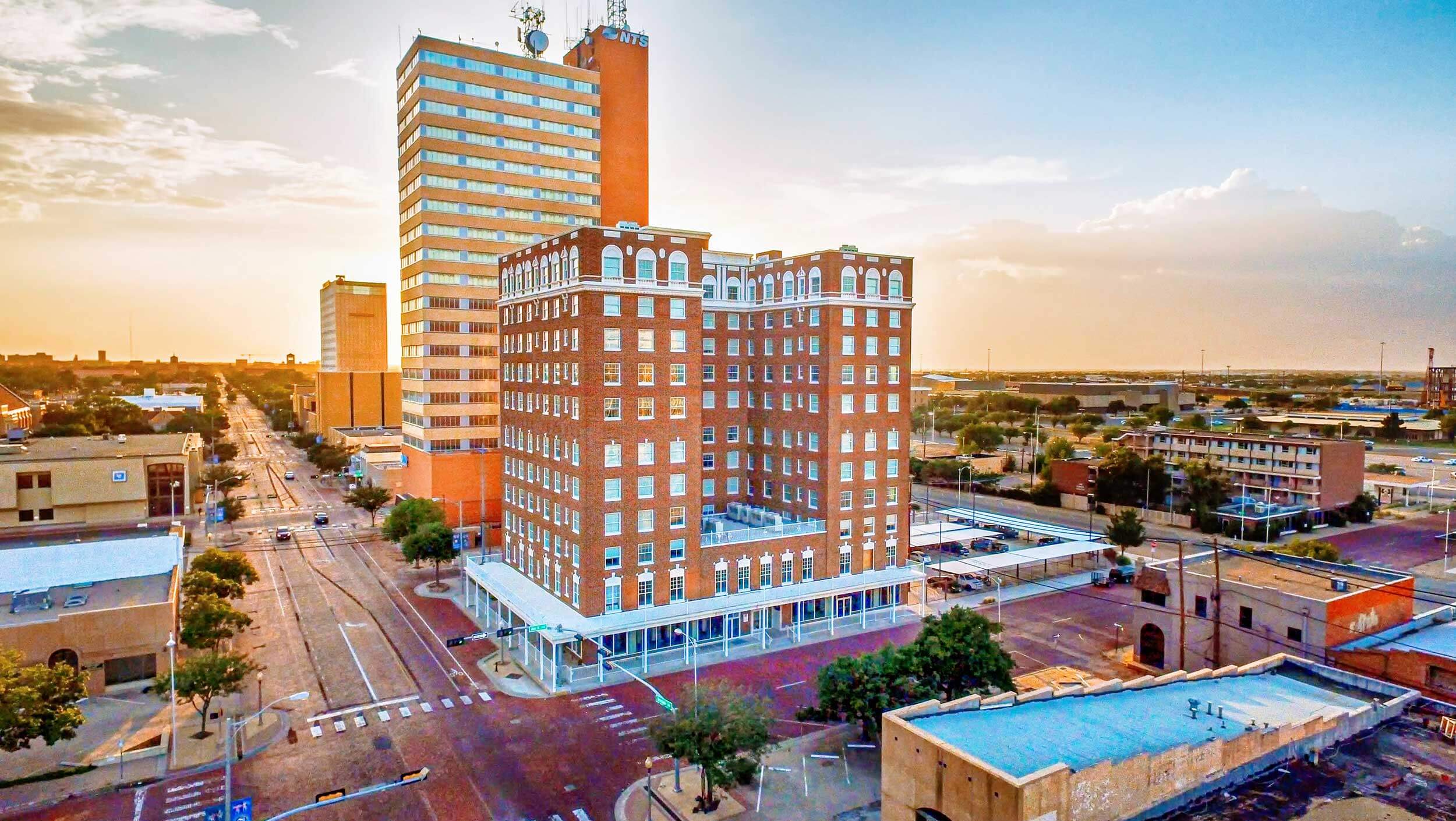 The brown Pioneer building in downtown Lubbock, Texas is seen on the corner at sunrise