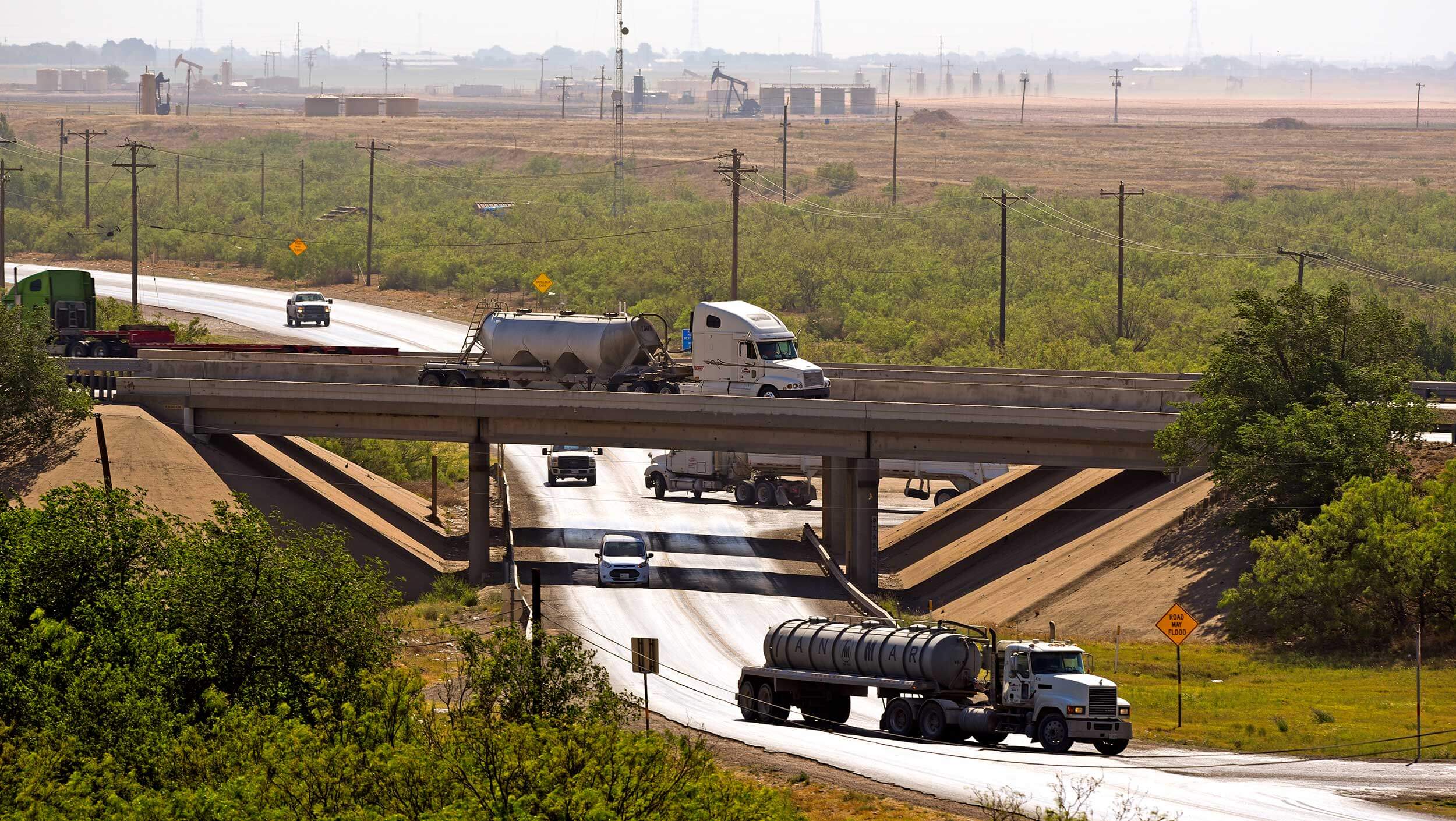 A white truck drives on an elevated overpass above another highway in Midland, Texas