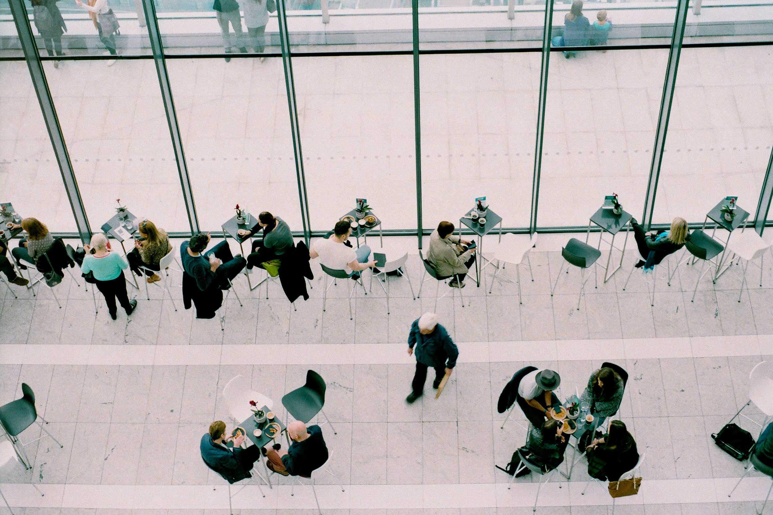 Overhead shot of a downstairs cafe where people can be seen eating, networking, and working