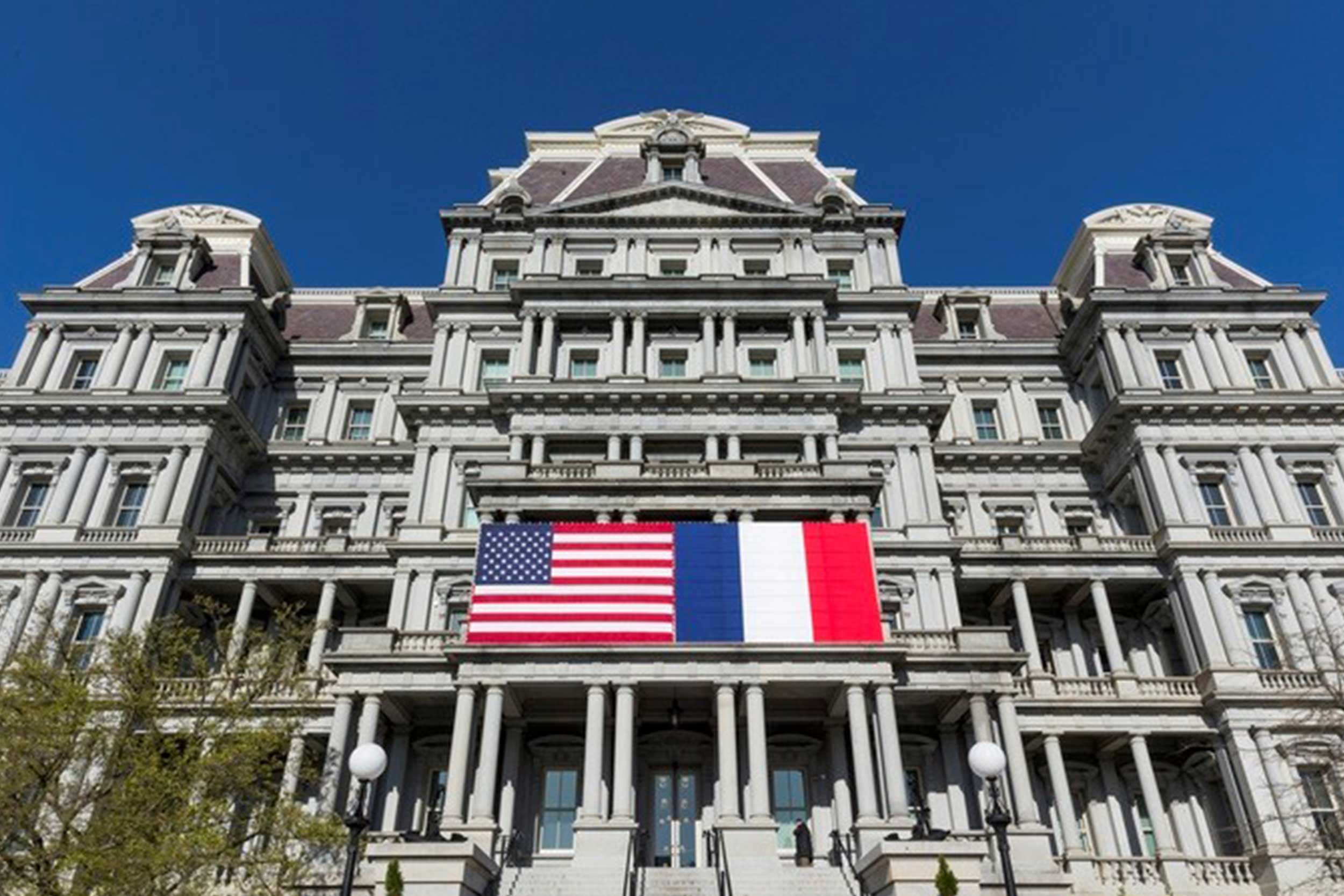 A large building displays the US and French flag