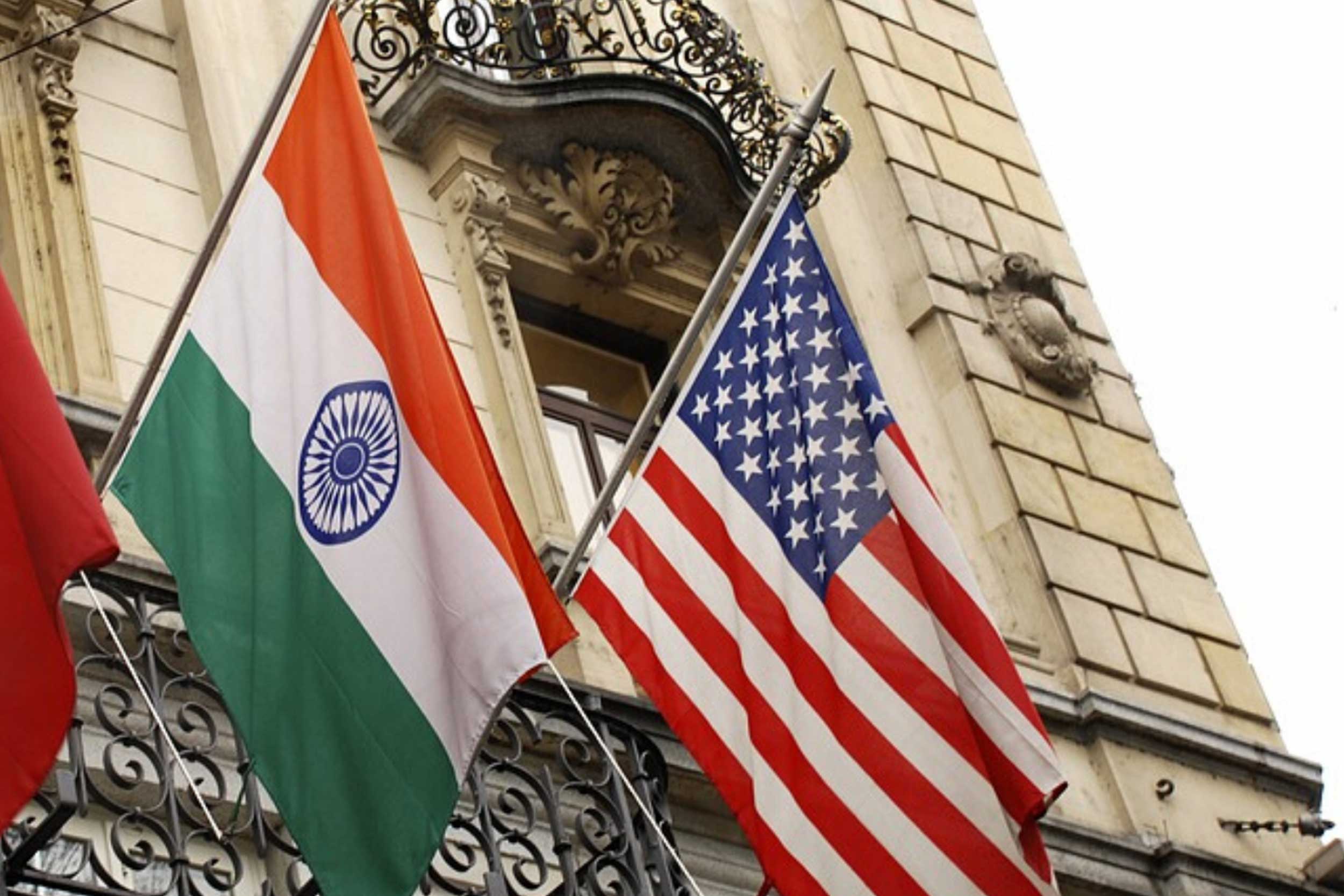 The India and US flag are raised onto a building