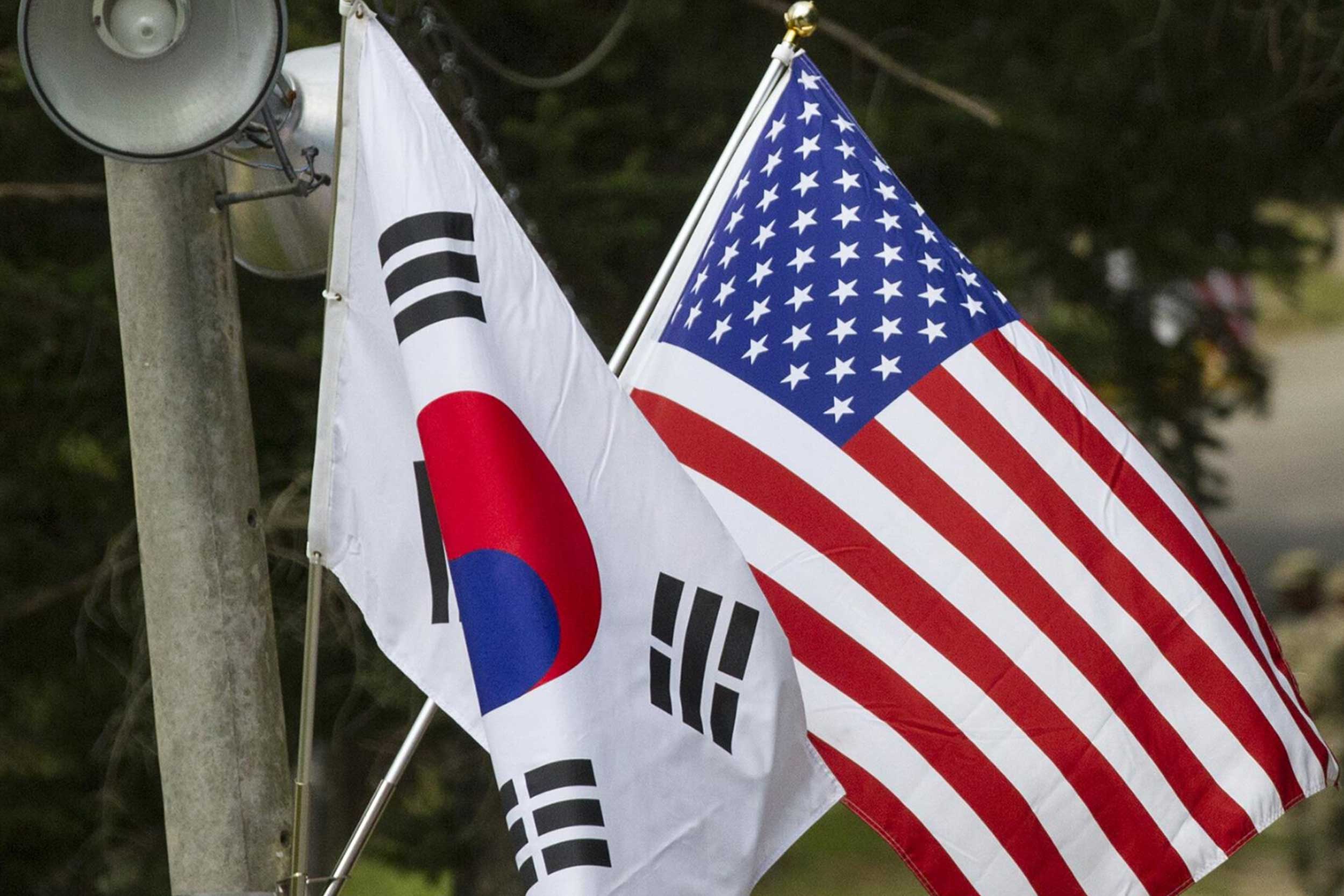 The South Korean flag and US flag hang on a utilities pole