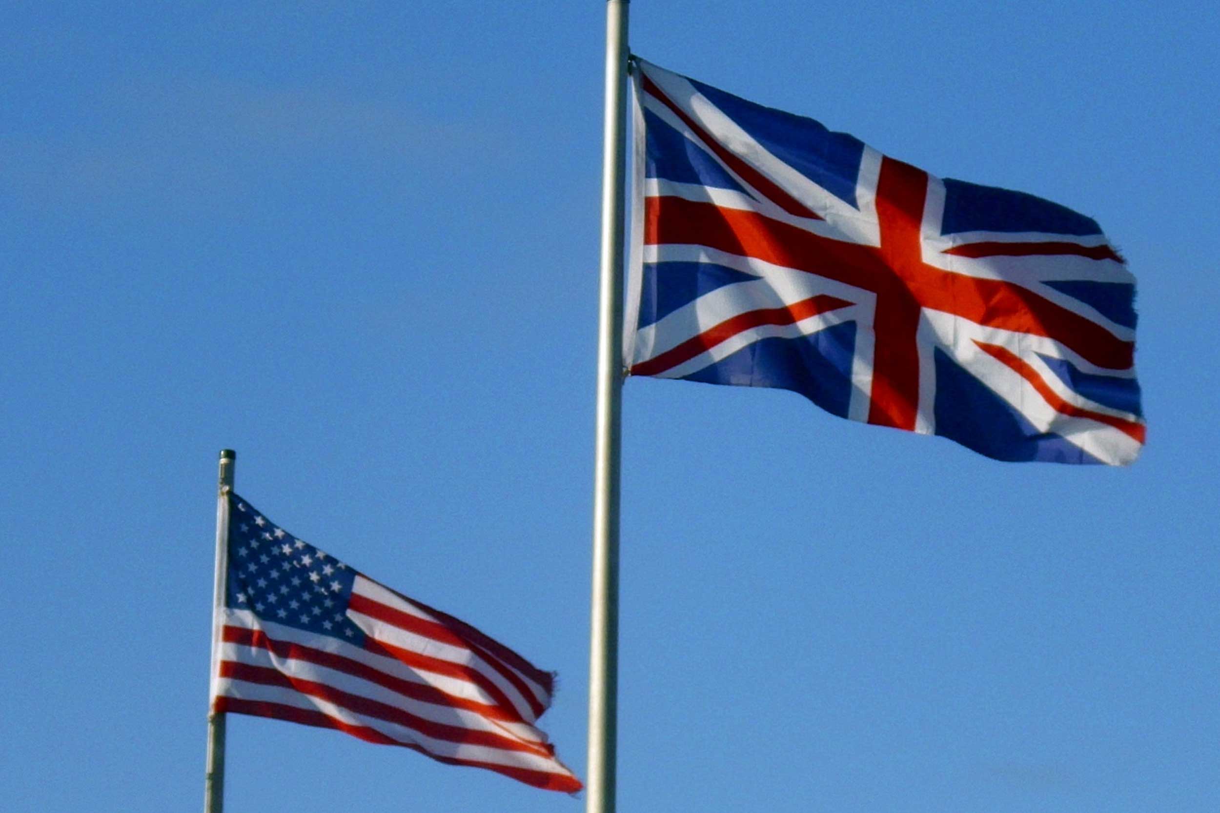 A UK flag and US flag flying in the sky next to each other