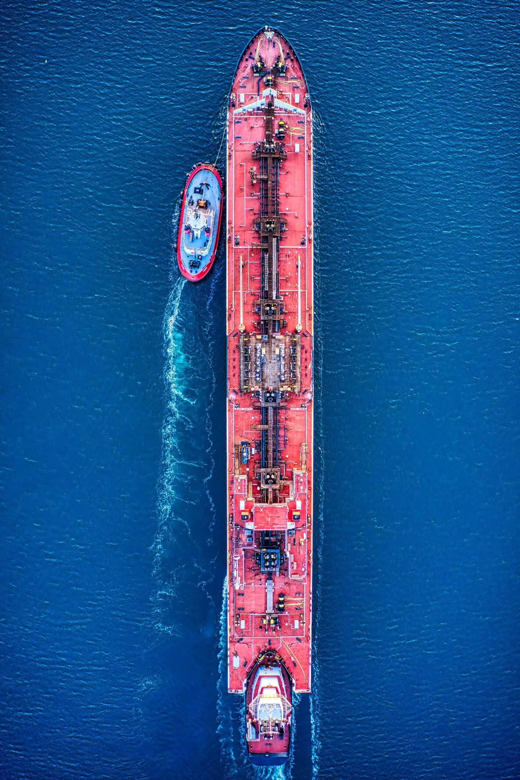 An aerial shot of a large cargo ship moving through the ocean